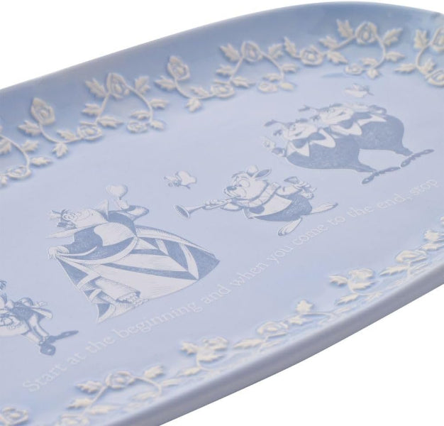 Decorative tray with white floral and character design on a light blue background