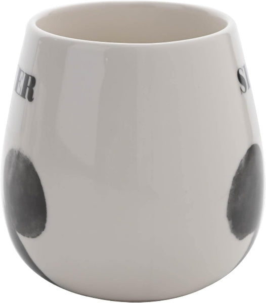 White ceramic cup with black polka dots on a white background