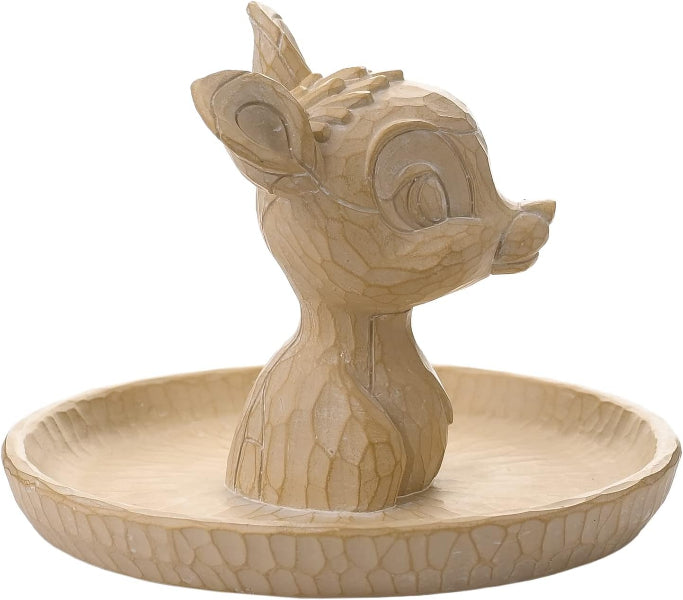 Wooden deer figurine on a circular base with a plain background