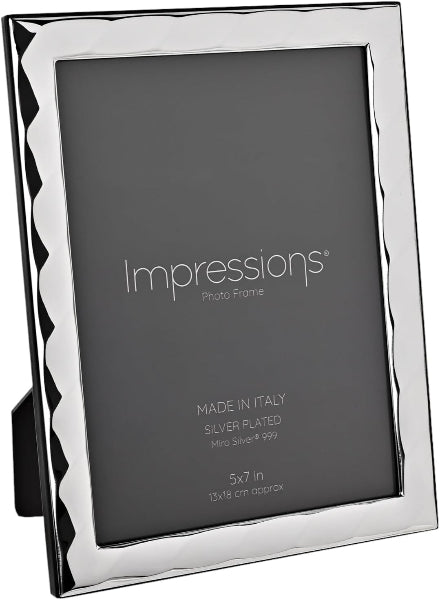 A silver-plated picture frame with a wavy, scalloped edge design, shown standing at an angle on a black background. The frame is branded 'Impressions' on the insert card, which is included in the subject bounding box.