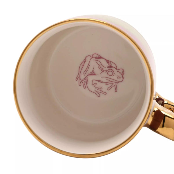 Beige mug with gold rim and handle featuring a red frog logo on a white background