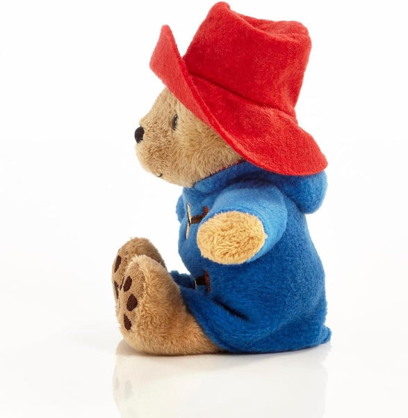 Plush toy bear in a red hat and blue coat on a white background