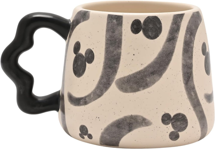 Ceramic mug with black abstract patterns on a beige background