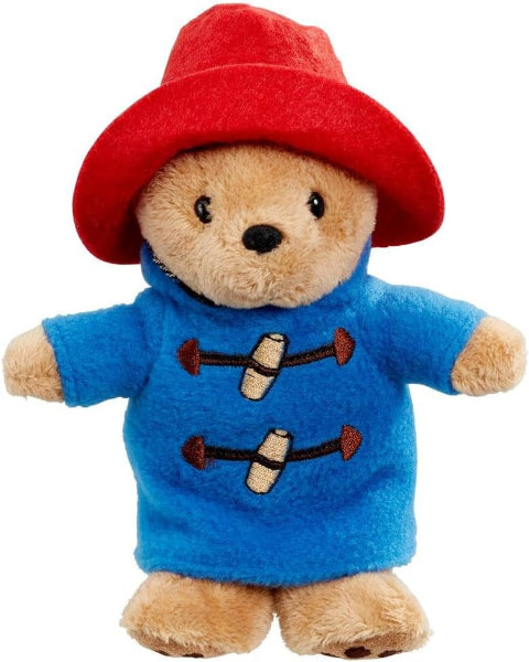 Plush toy bear wearing a red hat and blue coat with brown buttons on a white background