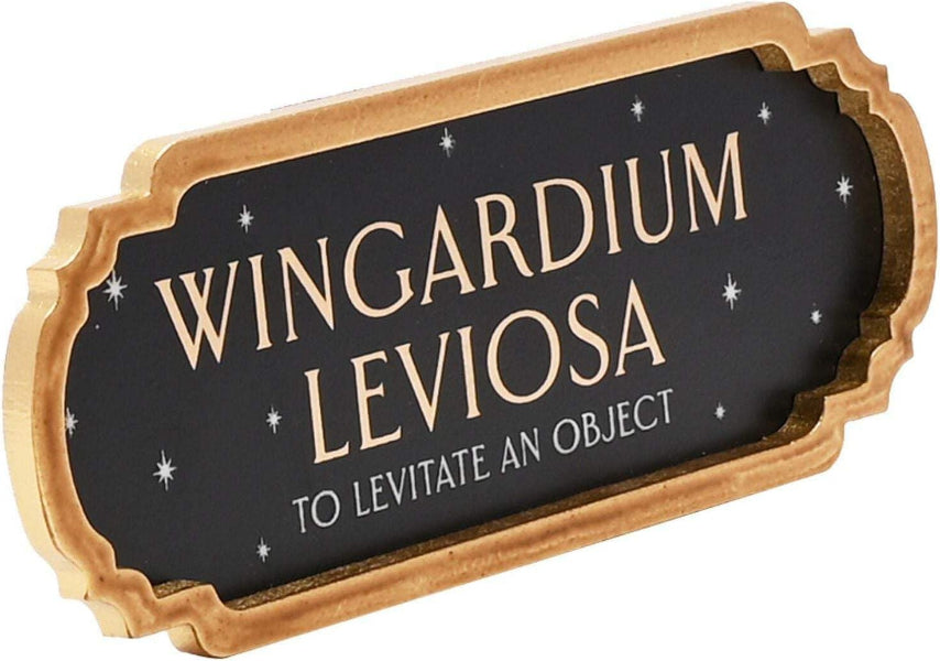 Decorative sign with 'Wingardium Leviosa' text on a black background with gold frame