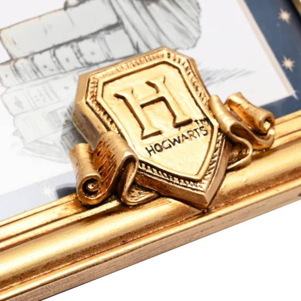 Gold tie clip with Hogwarts crest on a decorative background