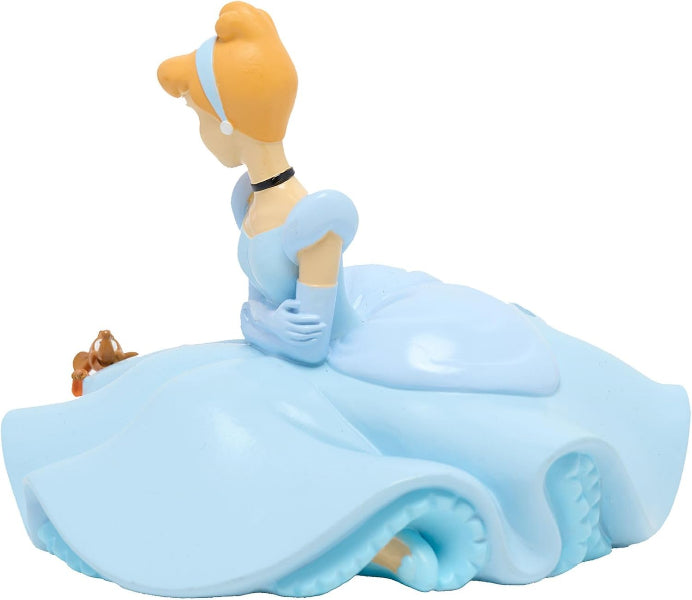 A Cinderella figurine in profile, wearing her signature light blue gown and matching headpiece, with her signature orange hair and a small brown suitcase beside her, set against a plain white background.