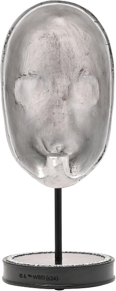 Decorative sculpture of a face in a shell-like structure on a black stand.