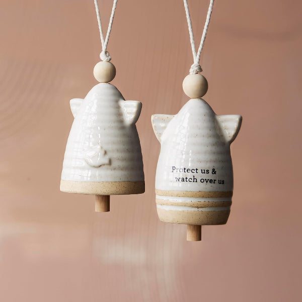 Two ceramic angel-shaped ornaments with wooden accents on a soft brown background.