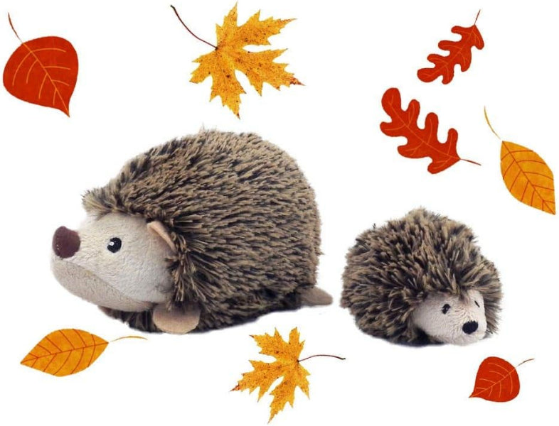 Two toy hedgehogs with autumn leaves on a white background