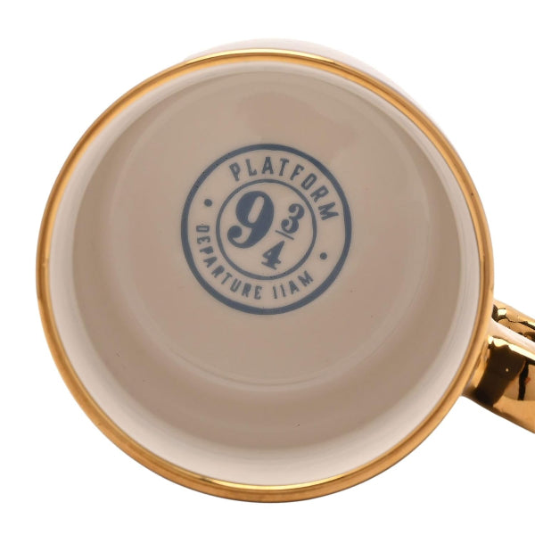 Mug with gold rim and handle featuring a blue 'Platform 9 3/4' design on a beige background