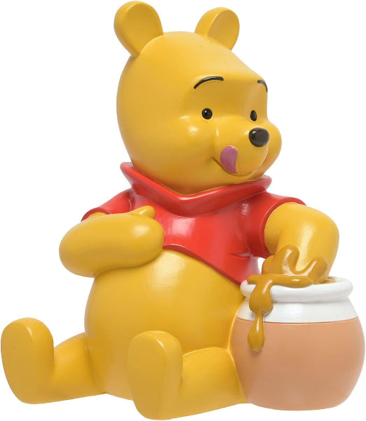 Yellow bear character with a red shirt holding a honey pot on a white background