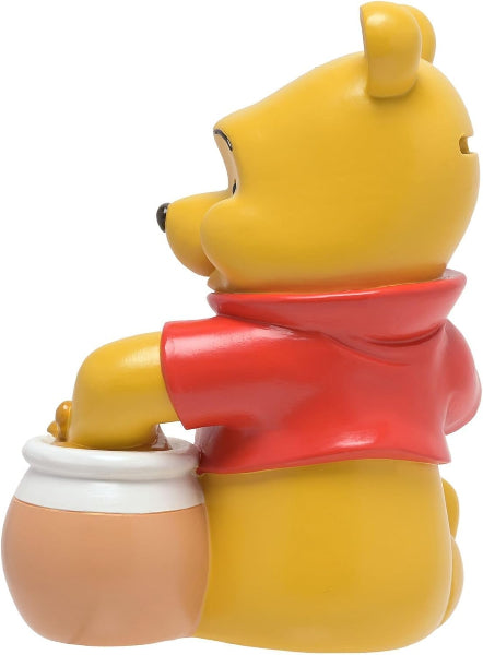 Yellow bear character with a red shirt holding a white container on a white background