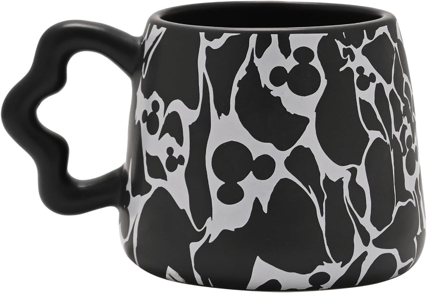 Black mug with white silhouette pattern on a white background