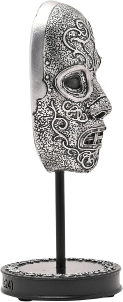 Decorative skull sculpture with intricate designs on a stand against a white background