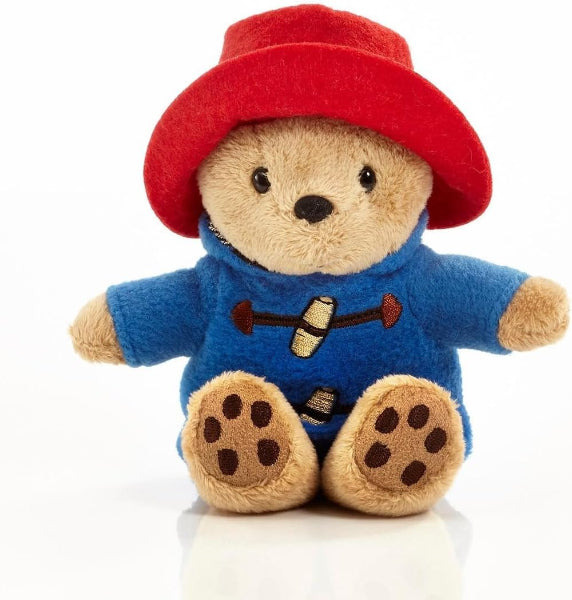 Plush toy bear wearing a red hat and blue sweater on a white background
