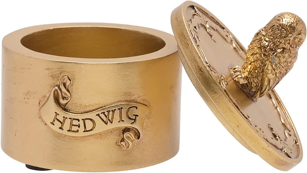 Gold-colored container with 'Hedwig' inscription and owl design on a white background
