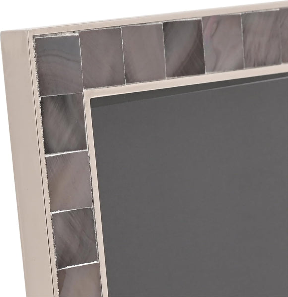 Close-up of a picture frame corner with a beige frame and a border of square reflective mirror tiles showing gray and silver reflections.