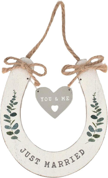 Decorative wooden horseshoe with 'You & Me' heart and 'Just Married' text on a white background