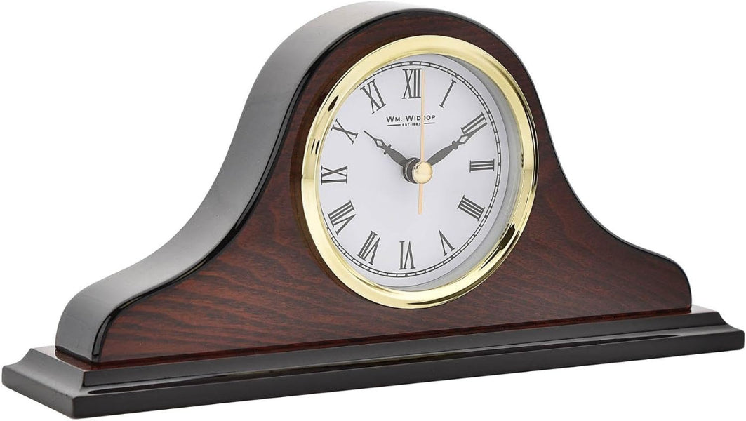 A classic mantel clock with a dark brown wood grain body, a polished black top arch, a gold bezel, and a white dial with black Roman numerals.