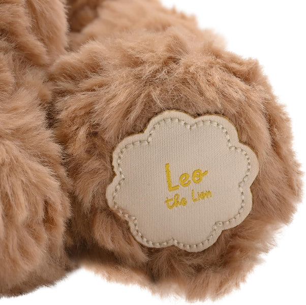 Close-up of a fluffy toy paw with 'Leo the Lion' label on a white background