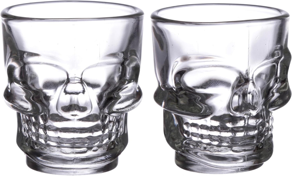 Two clear skull-shaped shot glasses on a white background