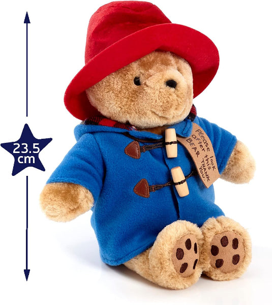 Plush toy bear in a blue coat and red hat with a measurement label on a white background