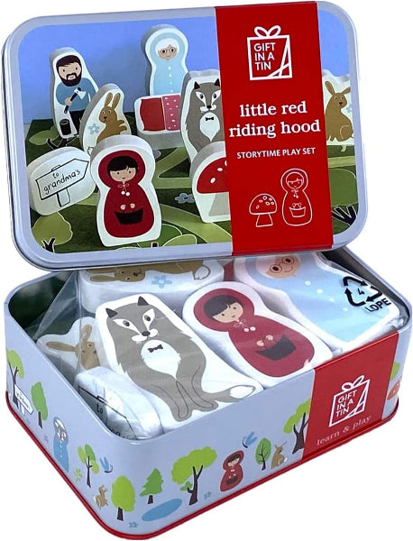 Gift in a tin Little Red Riding Hood storytime play set, featuring a decorative metal tin with illustrated cover art and a red paper band, containing wooden play pieces including a wolf, red-cloaked figures, mushrooms, and small characters.