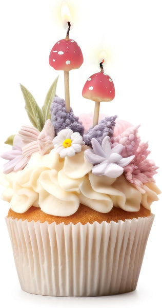 Cupcake with floral decorations and mushroom-shaped candles on a white background