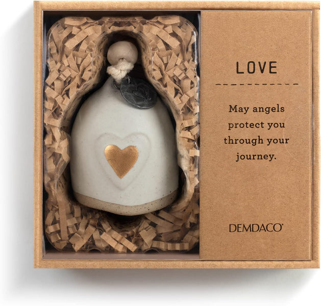 A ceramic angel figurine with a white body, gold heart, and dark glass eyes, presented inside a kraft gift box with shredded paper and a card that reads 'LOVE' and 'DEMDAO'.