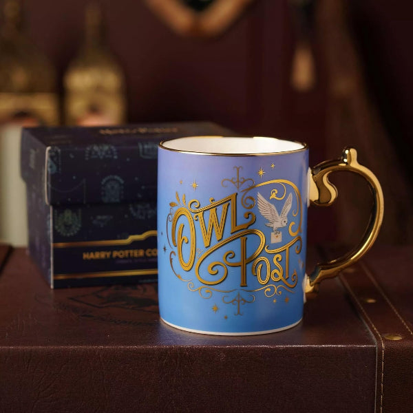 Blue mug with gold text 'Owl Post' on a wooden surface with a blurred background