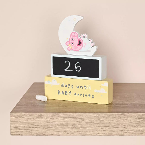 Baby countdown timer with cartoon design on a wooden stand against a beige background