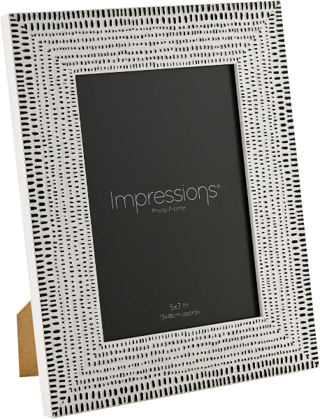 A 5x7 inch picture frame by Impressions, featuring a textured white frame with a black dotted geometric pattern and a black insert card.