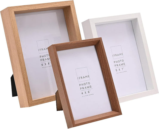 Three picture frames shown on a white background: two natural wood frames in the foreground and one white frame behind them. The front wood frame is angled and larger in prominence, with the other two frames partially overlapping behind it.