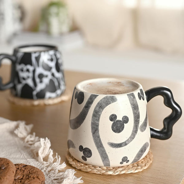 Ceramic mugs with black abstract patterns on a wooden surface