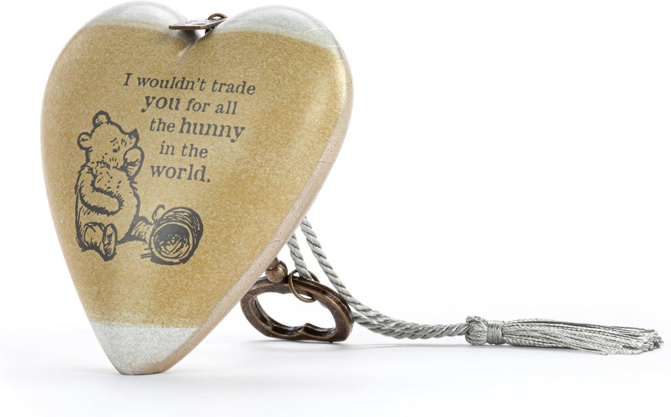 A heart-shaped wooden keepsake box with a silver tassel and metal clasp, featuring Winnie the Pooh illustration and the quote 'I wouldn't trade you for all the honey in the world.' on a white background.