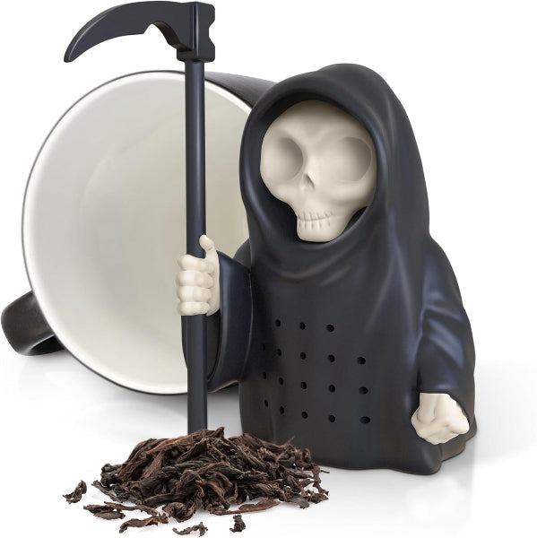 Tea infuser shaped like a skeleton holding a scythe with loose tea leaves on a white background