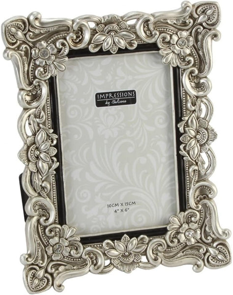 Decorative silver photo frame with floral patterns on a white background
