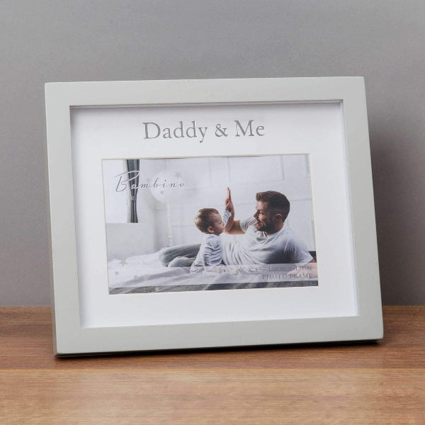 White photo frame with 'Daddy & Me' text, displaying a photo of a father and child, on a wooden surface.