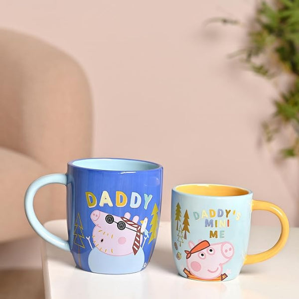 Two colorful mugs with cartoon characters on a light surface.