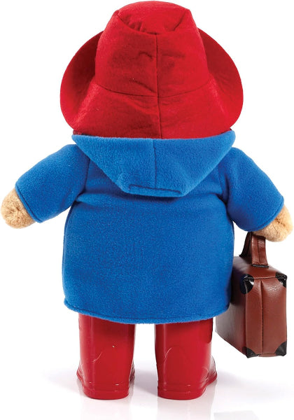 Toy figure wearing a blue coat, red boots, and holding a suitcase on a white background