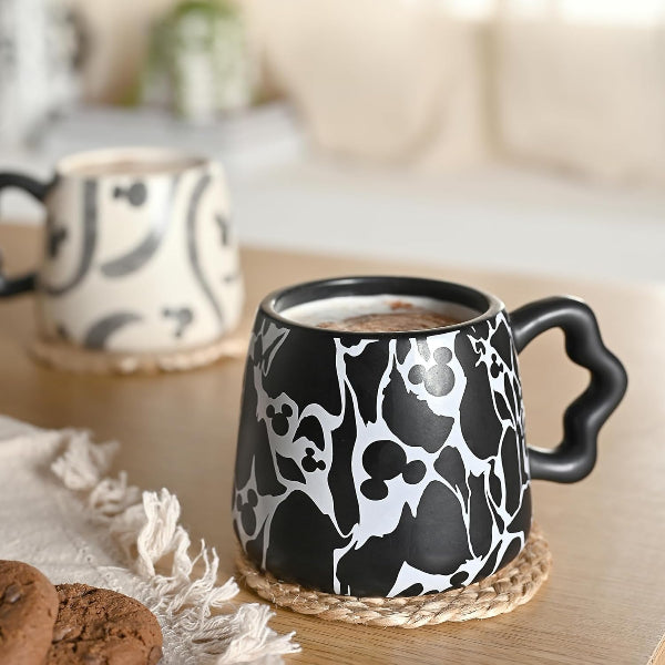 Black and white patterned mug with a handle on a wooden table.