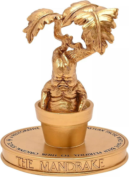 Gold figurine of a mandrake plant on a white background