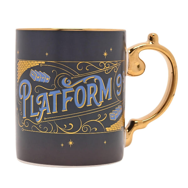 A dark navy blue ceramic mug with a gold handle and gold rim, featuring a 'Platform 9 3/4' design inspired by Harry Potter, with blue and gold lettering and brick patterns on a white background.