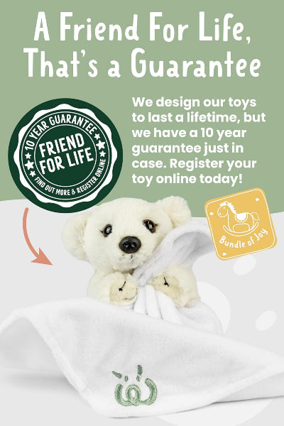 White teddy bear with a green label and text about a 10-year guarantee on toys.