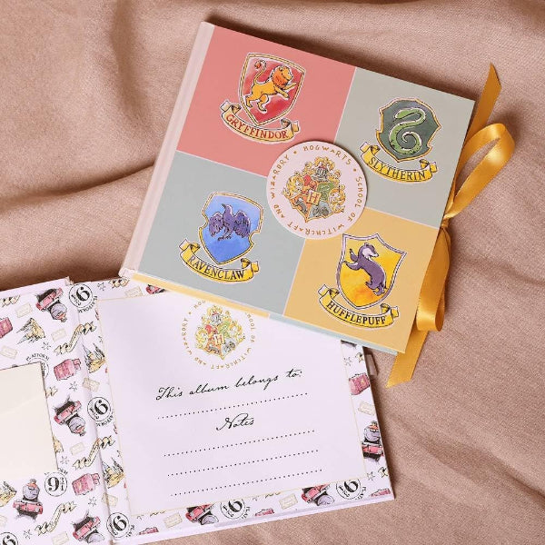 Notebook with Hogwarts house crests on a beige fabric background