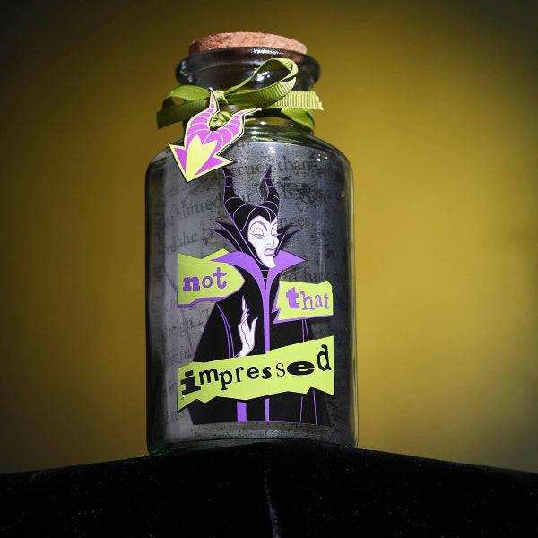 Decorative glass bottle with a character silhouette and text on a yellow background