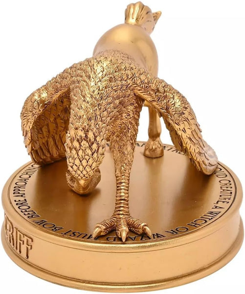 Gold statue of a Griffin on a circular base with text