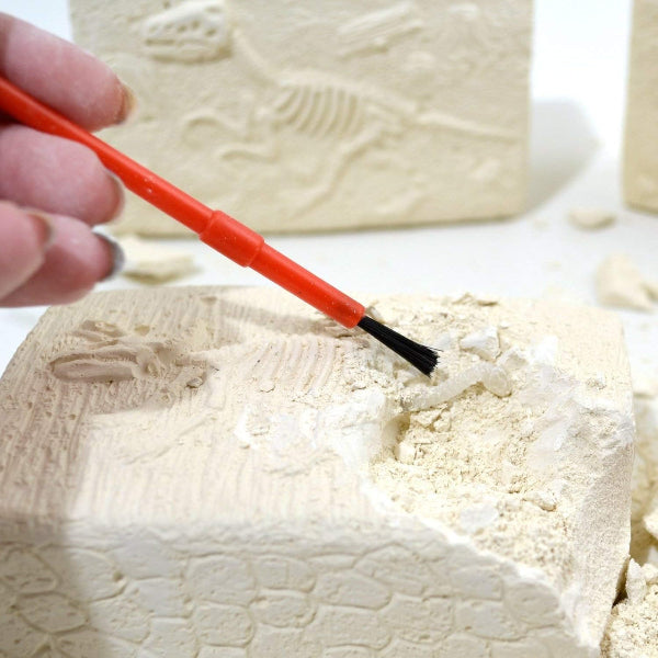 Person using a red tool with a black tip on a textured white surface