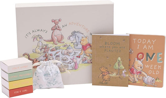 Collection of children's books and a box with Winnie the Pooh illustrations on a white background